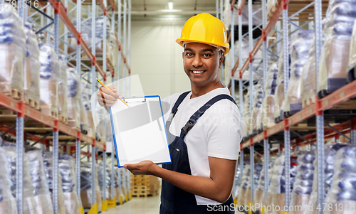 Image of happy indian worker with clipboard at warehouse