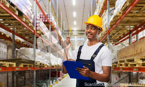 Image of happy worker or loader with clipboard at warehouse