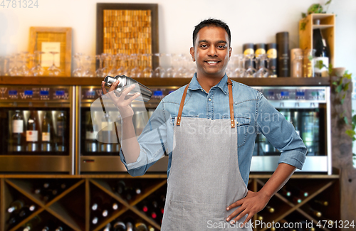 Image of indian barman in apron with cocktail shaker at bar