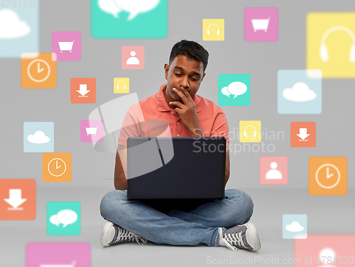 Image of thinking indian man with laptop over app icons