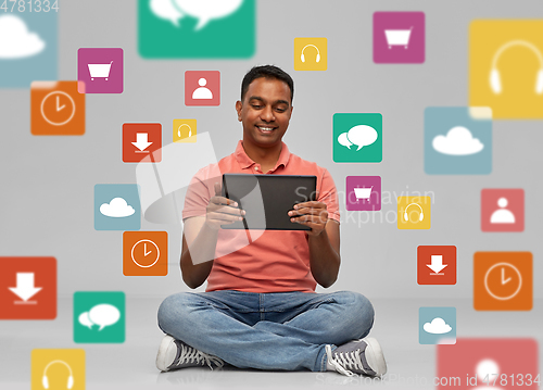 Image of happy indian man with tablet pc over app icons