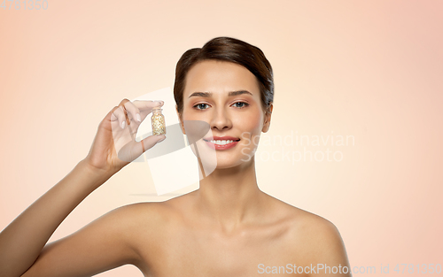 Image of beautiful young woman with gold facial mask