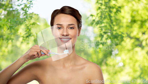 Image of smiling woman with toothbrush cleaning teeth