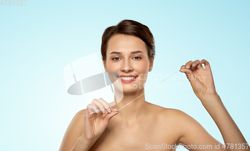 Image of happy young woman with dental floss cleaning teeth