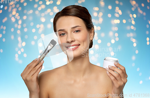 Image of beautiful young woman with facial mask and brush