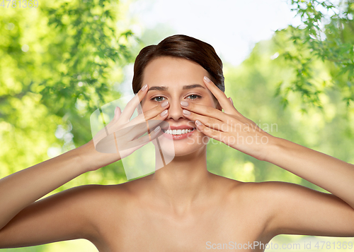 Image of beautiful young woman touching her face