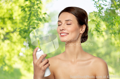 Image of beautiful young woman with facial spray or mist