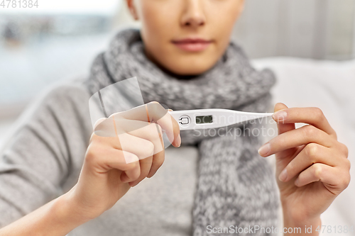 Image of sick woman measuring temperature by thermometer