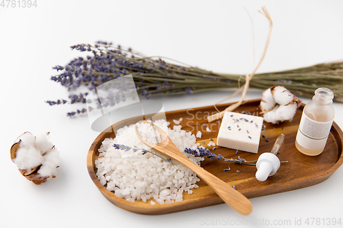 Image of sea salt, lavender soap and serum on wooden tray