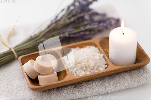 Image of sea salt, soap, candle and lavender on bath towel