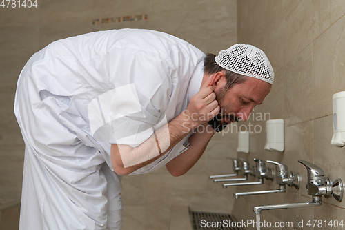 Image of A Muslim takes ablution for prayer. Islamic religious rite