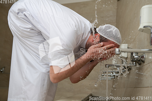 Image of A Muslim takes ablution for prayer. Islamic religious rite