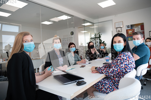 Image of real business people on meeting wearing protective mask