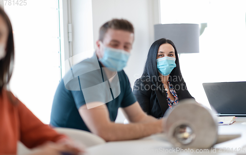 Image of real business people on meeting wearing protective mask