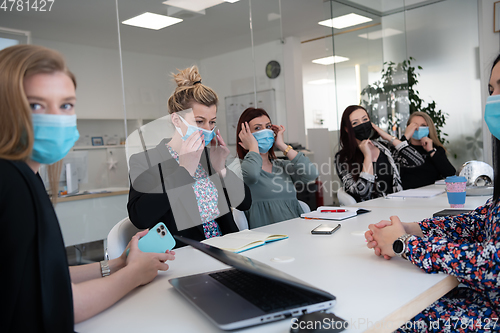 Image of real business people on meeting wearing protective mask