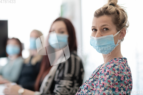 Image of real business people on meeting wearing protective mask