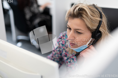 Image of call center operator in medical mask