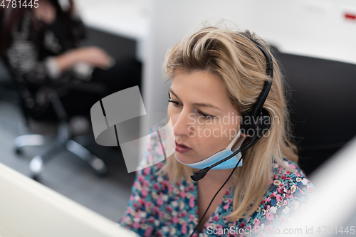 Image of call center operator in medical mask