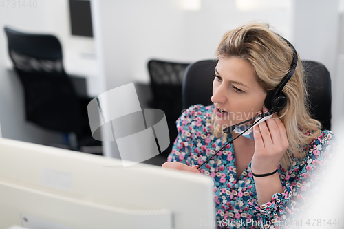 Image of call center operator in medical mask