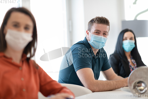 Image of real business people on meeting wearing protective mask