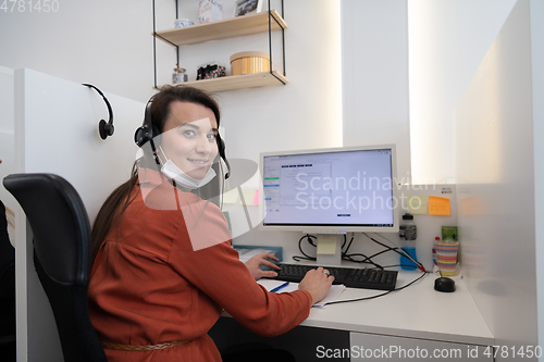 Image of call center operator in medical mask