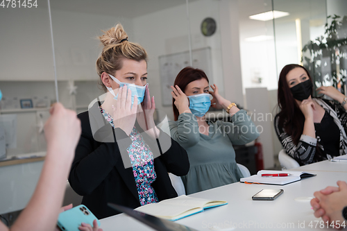 Image of real business people on meeting wearing protective mask