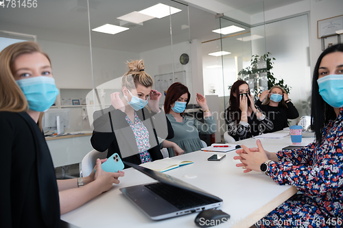 Image of real business people on meeting wearing protective mask