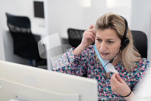 Image of call center operator in medical mask