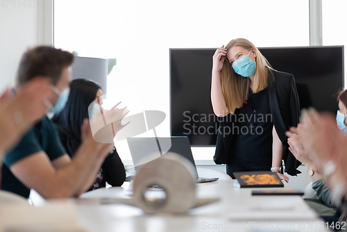 Image of real business people on meeting wearing protective mask