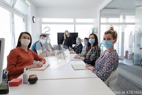 Image of real business people on meeting wearing protective mask