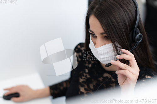 Image of call center operator in medical mask