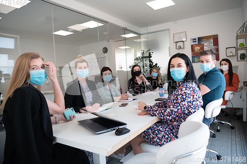 Image of real business people on meeting wearing protective mask