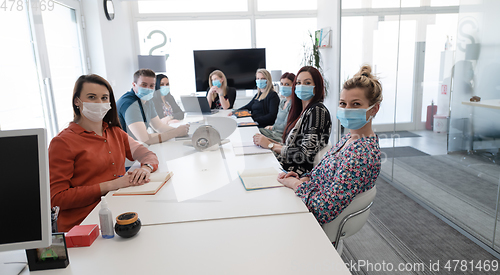 Image of real business people on meeting wearing protective mask