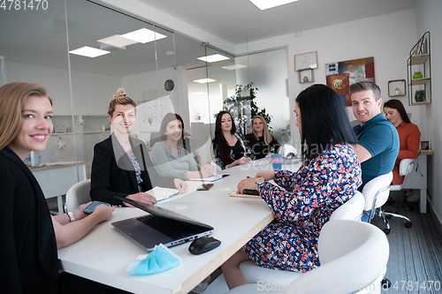 Image of real business people on meeting wearing protective mask