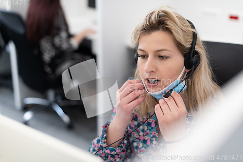 Image of call center operator in medical mask