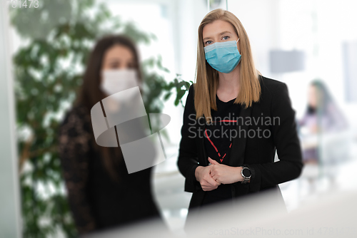 Image of business team in protective medical mask at modern office