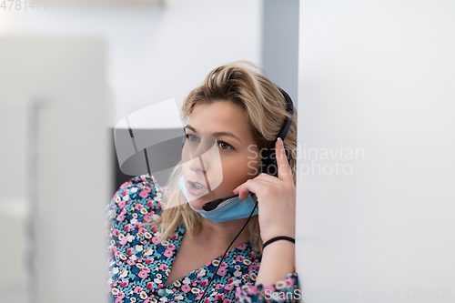 Image of call center operator in medical mask