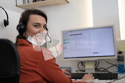 Image of call center operator in medical mask