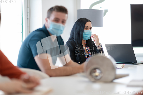 Image of real business people on meeting wearing protective mask