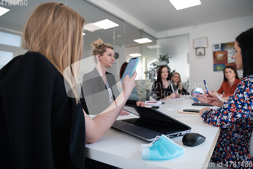 Image of business woman as team leader on meeting checking phone messages