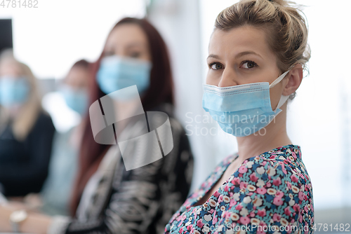 Image of real business people on meeting wearing protective mask