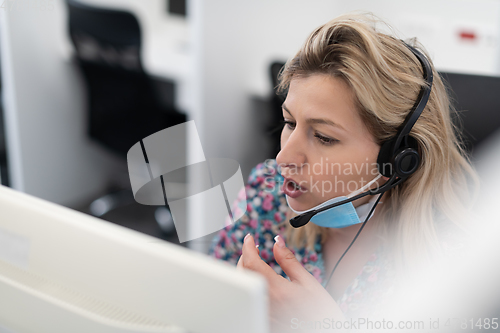 Image of call center operator in medical mask