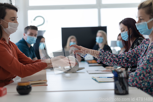 Image of new normal businesspeople on meeting using antibacterial hand sanitizer