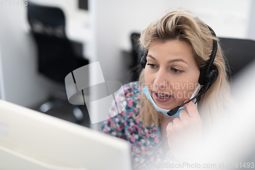 Image of call center operator in medical mask