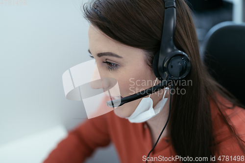 Image of call center operator in medical mask