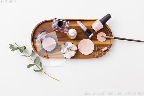 Image of makeup, perfume and cosmetics on wooden tray