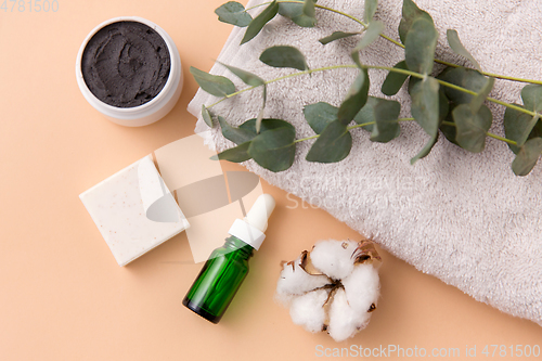 Image of serum, clay mask, oil and eucalyptus on bath towel