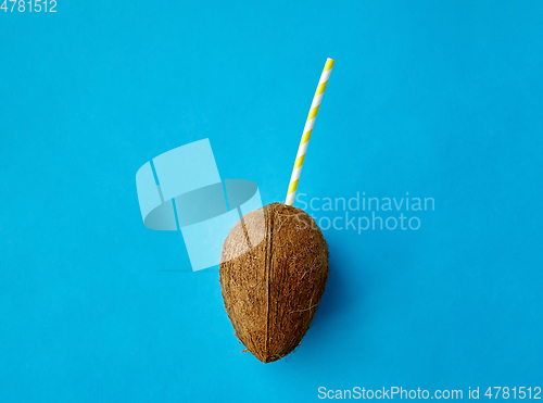 Image of coconut drink with paper straw on blue background
