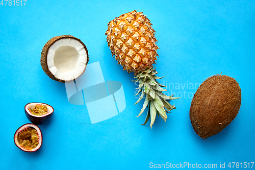 Image of pineapple, passion fruit and coconut on blue