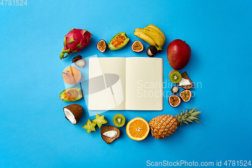 Image of exotic fruits around notebook with empty pages